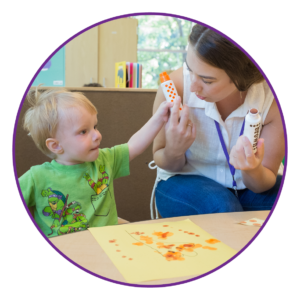 child and special educator painting